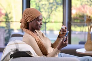 a patient getting onboard training on her phone while holding the connected device